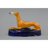 A 19th century Staffordshire pottery model of a greyhound with coursing collar,