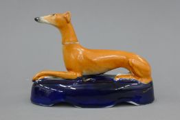 A 19th century Staffordshire pottery model of a greyhound with coursing collar,