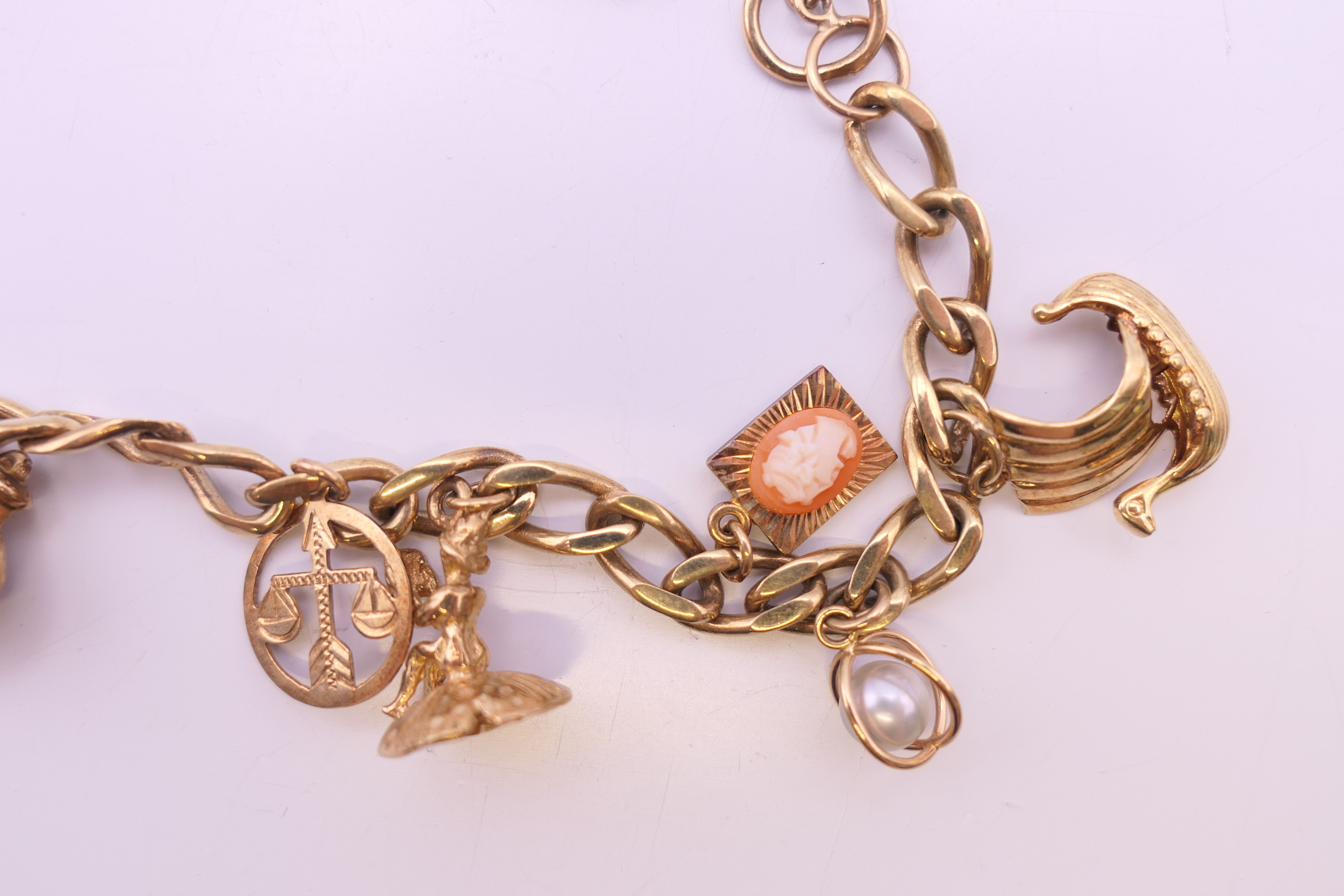 A 9 ct gold charm bracelet, set with various charms and an 1894 half sovereign. 25. - Image 3 of 6