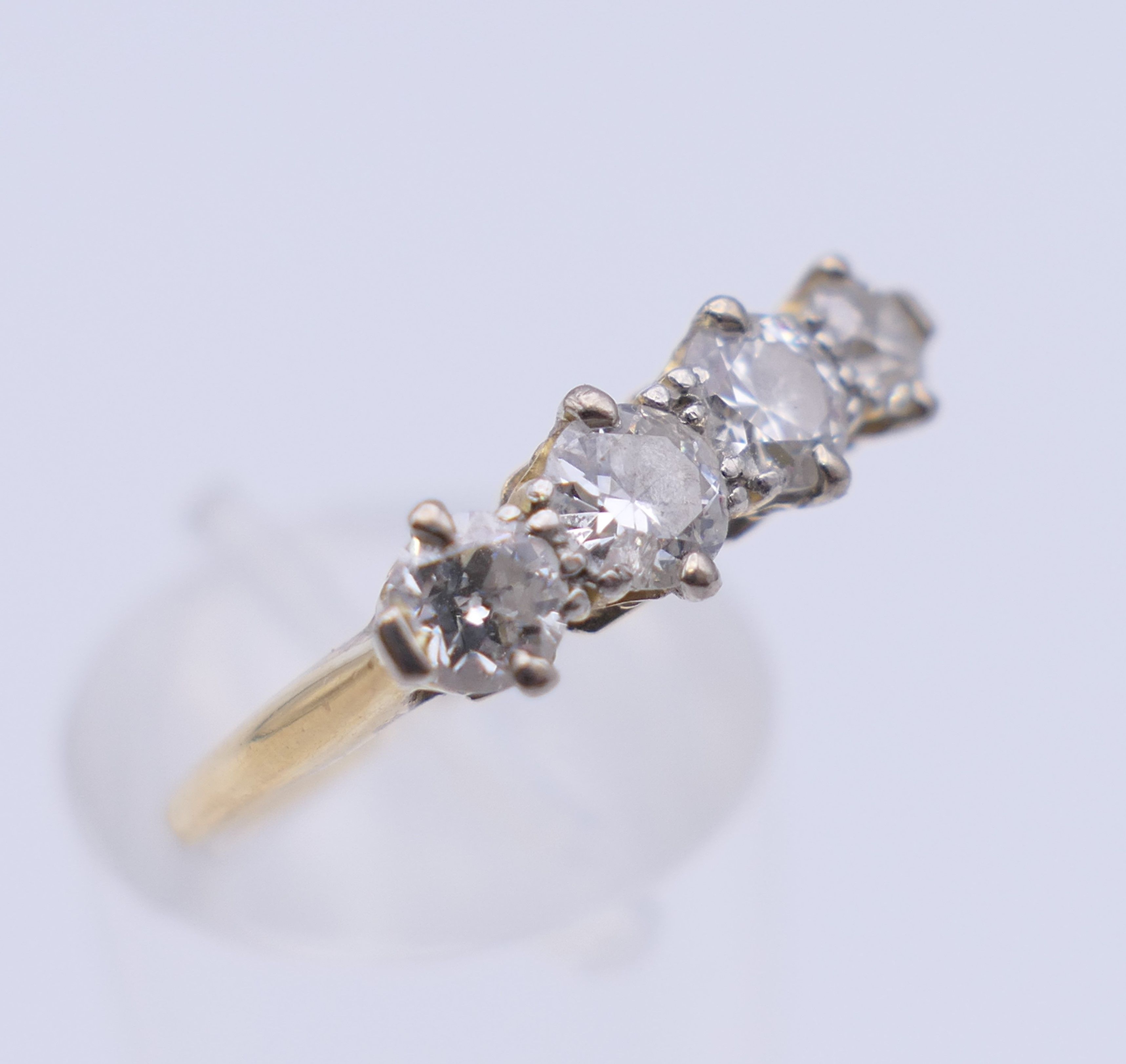 An unmarked gold four stone diamond ring. Ring size O. 2.7 grammes total weight. - Image 4 of 6