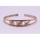An unmarked gold diamond set bangle form bracelet. 6.5 cm internal diameter. 5.