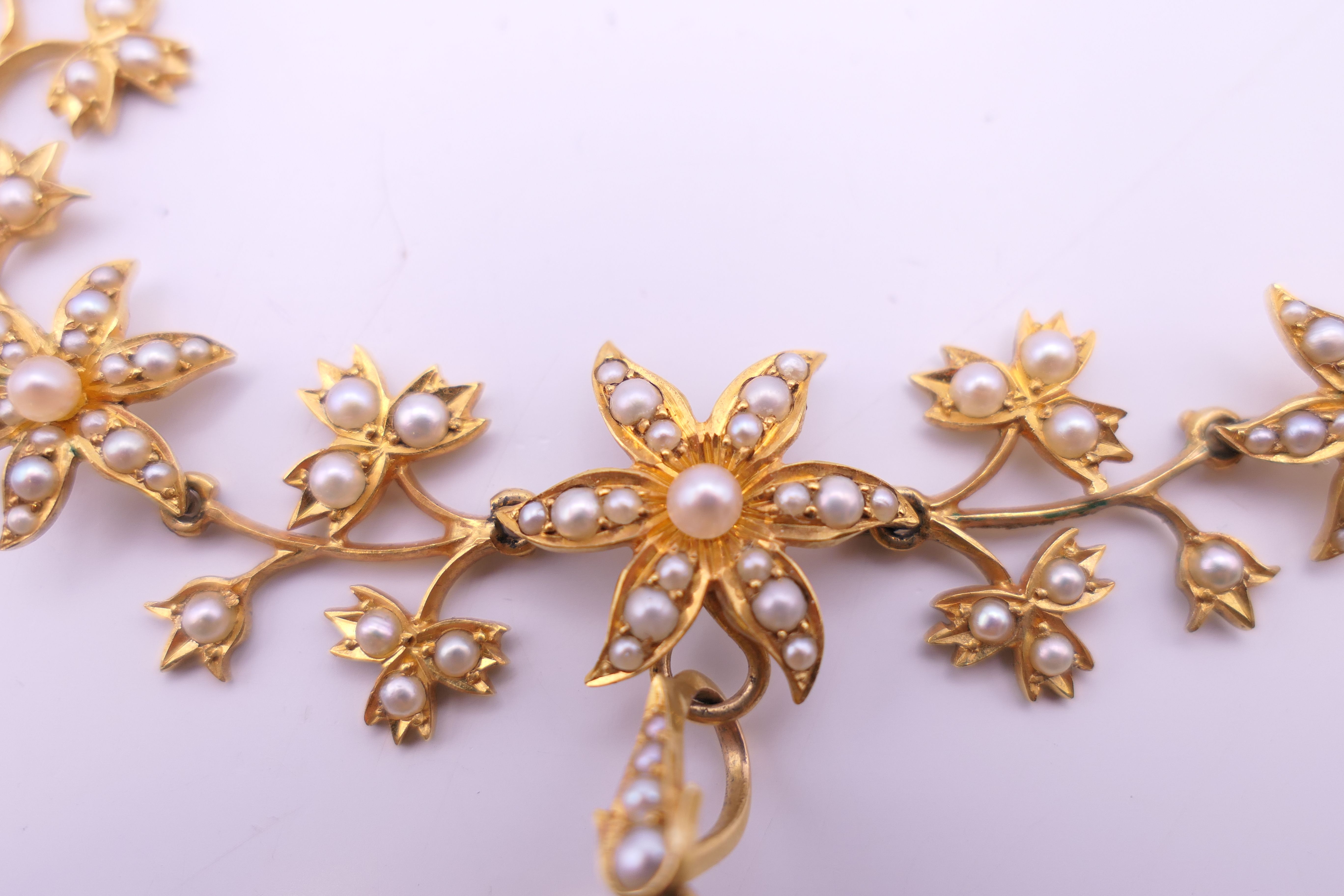 An unmarked gold seed pearl set necklace of scrolling floral form and detachable pendant formed as - Image 9 of 16