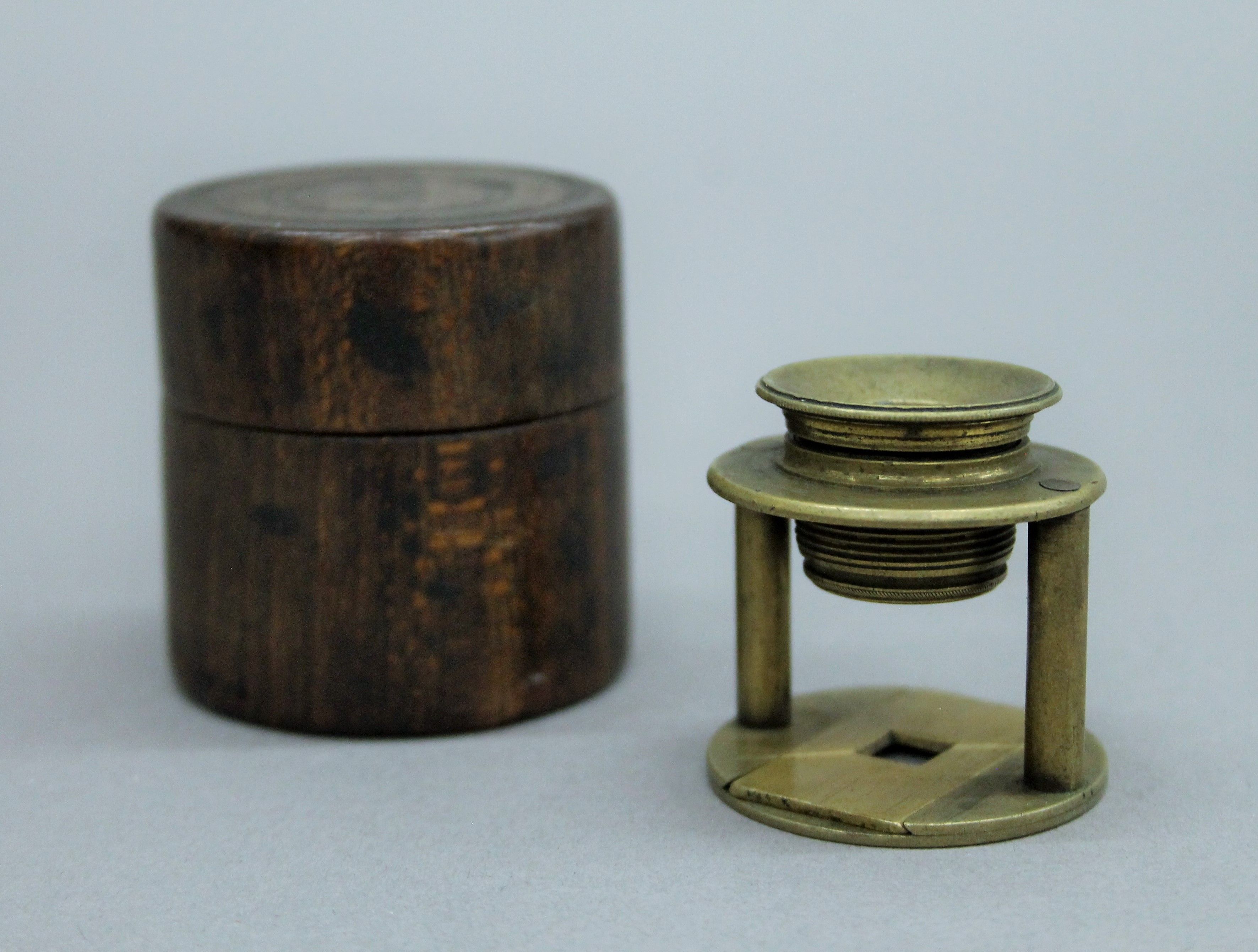 A 19th century brass travelling microscope in wooden case. The case 5 cm high.