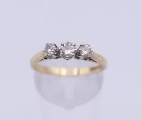 A 9 ct gold three stone diamond ring. Ring size O. 2.1 grammes total weight.