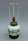 A Chinese porcelain lamp mounted on a wooden stand. 30 cm high excluding shade holder.