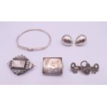 A quantity of silver jewellery including brooches, a bangle and a pair of earrings.