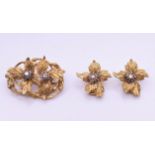 A Kutchinsky 18 ct gold diamond and sapphire set matching brooch and clip earrings of floral form.