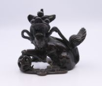 An 18th century Chinese bronze scroll weight in the form of a temple dog. 6 cm high.