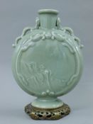A Japanese celadon moon vase mounted on a bronze base. 33 cm high.