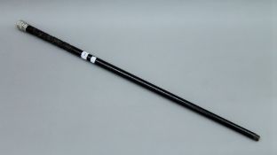 A 19th century Canton carved ebony walking stick with embossed unmarked silver handle. 90.5 cm long.