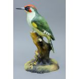 A Royal Crown Derby bone china model of a woodpecker,