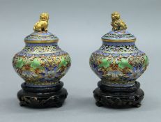 A pair of small Chinese cloisonne lidded vases on wooden stands. Each 10 cm high overall.