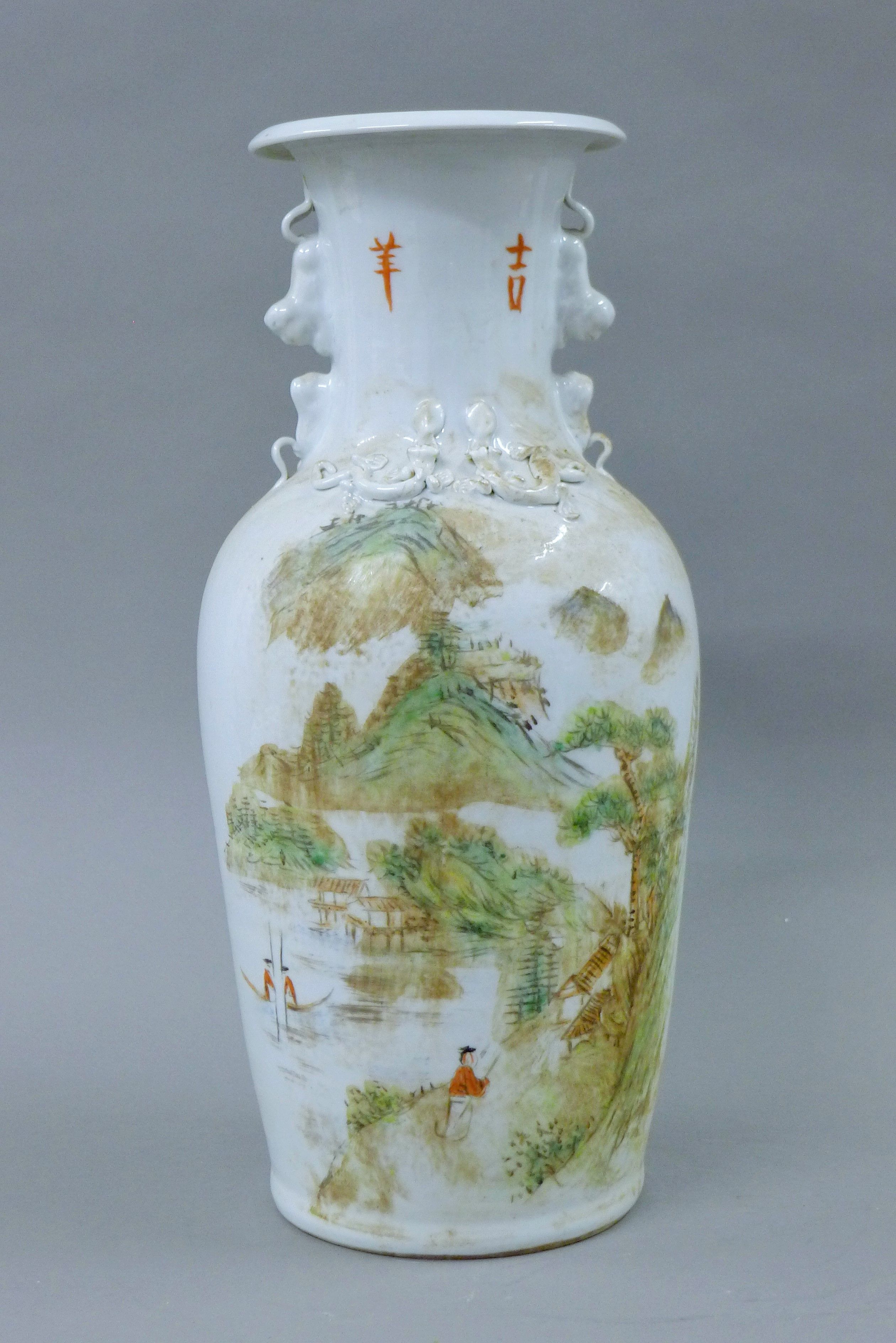 A Chinese porcelain vase decorated with figures in a mountainous landscape and calligraphy.