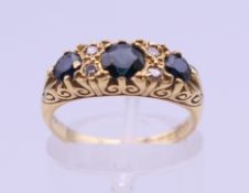 An 18 ct gold diamond and sapphire ring. Ring size L/M. 5 grammes total weight.