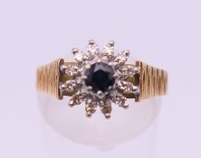 An 18 ct gold diamond and sapphire cluster ring. Ring size O/P. 4.8 grammes total weight.