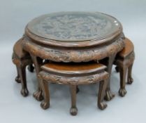An Oriental carved hardwood nest of tables. 73 cm diameter.