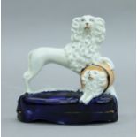 A 19th century Staffordshire pottery model formed as two poodles, one in a barrel. 12.5 cm high.