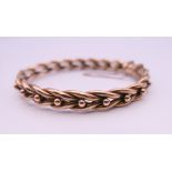 A 9 ct gold bangle form bracelet. 5.75 cm internal diameter. 10.9 grammes.