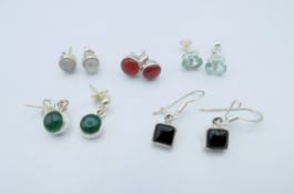 Five pairs of silver earrings. Black square earrings 0.5 x 0.5 cm.