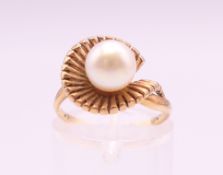 A 9 ct gold ring set with a 7 mm cultured pearl. Ring size I. 3.5 grammes total weight.