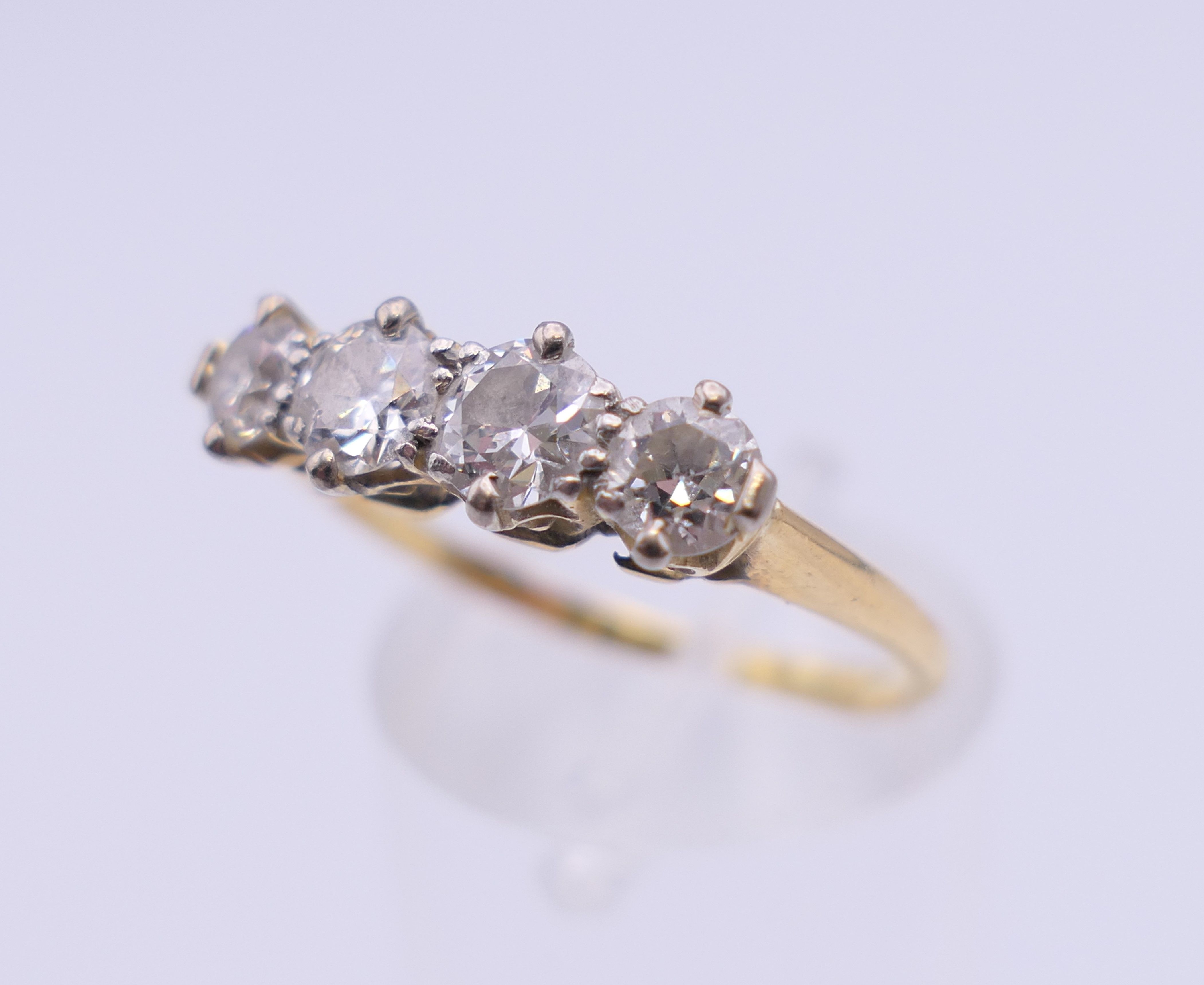 An unmarked gold four stone diamond ring. Ring size O. 2.7 grammes total weight. - Image 5 of 6