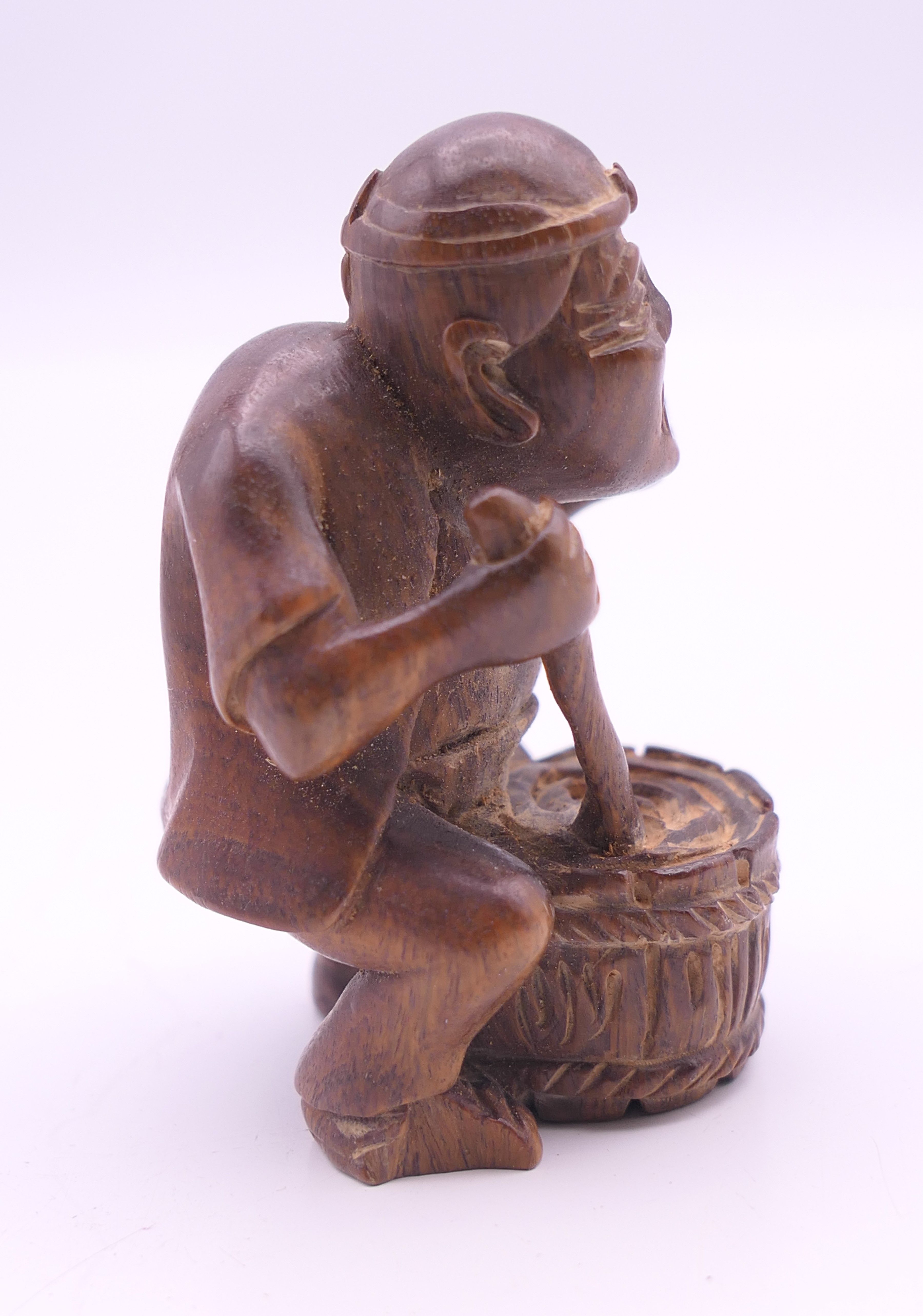 A netsuke formed as a man with a barrel. 6 cm high. - Image 2 of 4