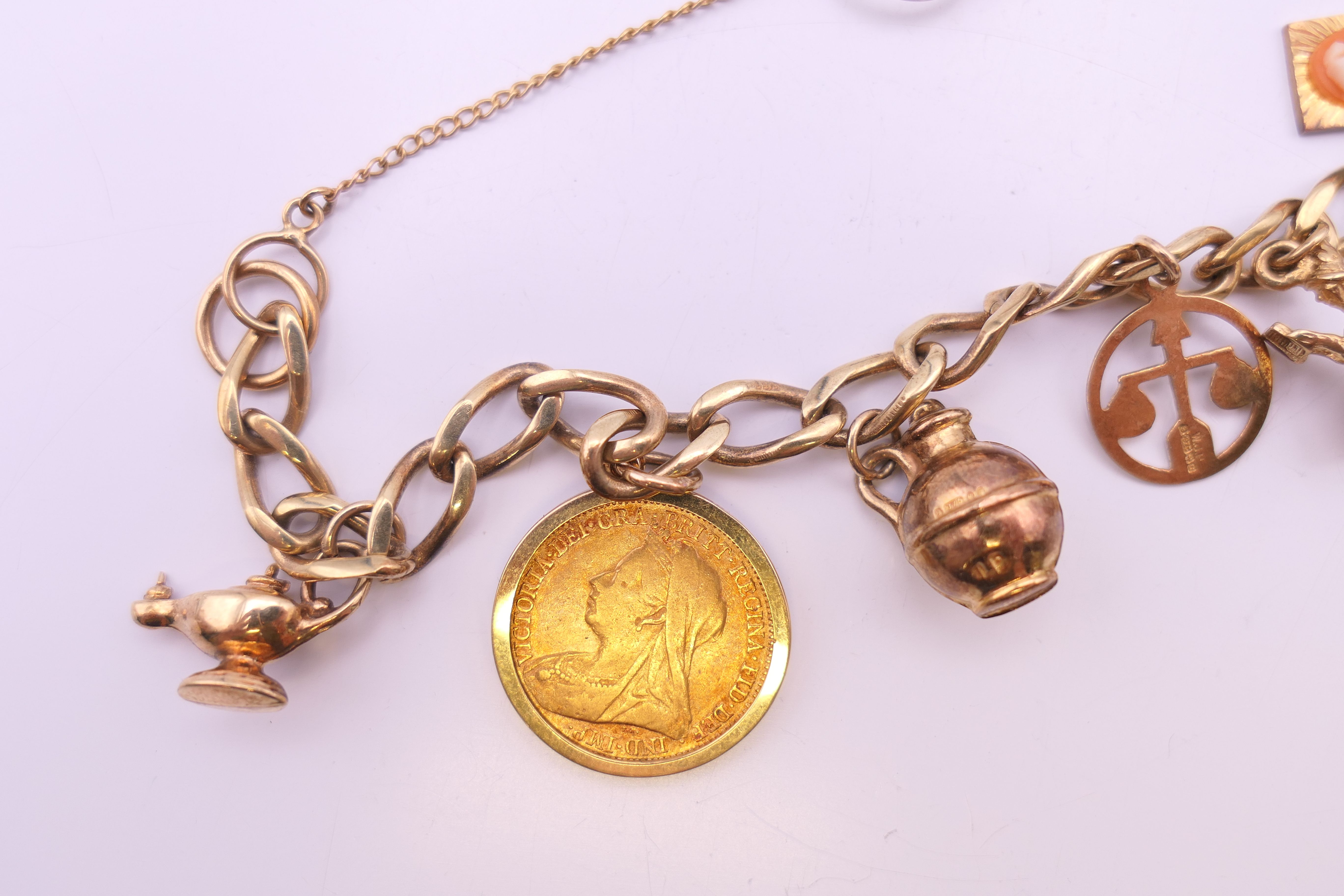 A 9 ct gold charm bracelet, set with various charms and an 1894 half sovereign. 25. - Image 2 of 6