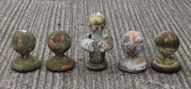 A pottery finial and four cast iron finials. The former 33 cm high.