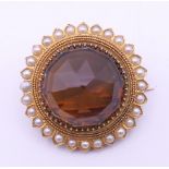 A Victorian unmarked gold citrine and seed pearl brooch. 3 cm diameter. 11.6 grammes total weight.
