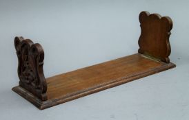 A Victorian carved oak book rack. 38 cm long.