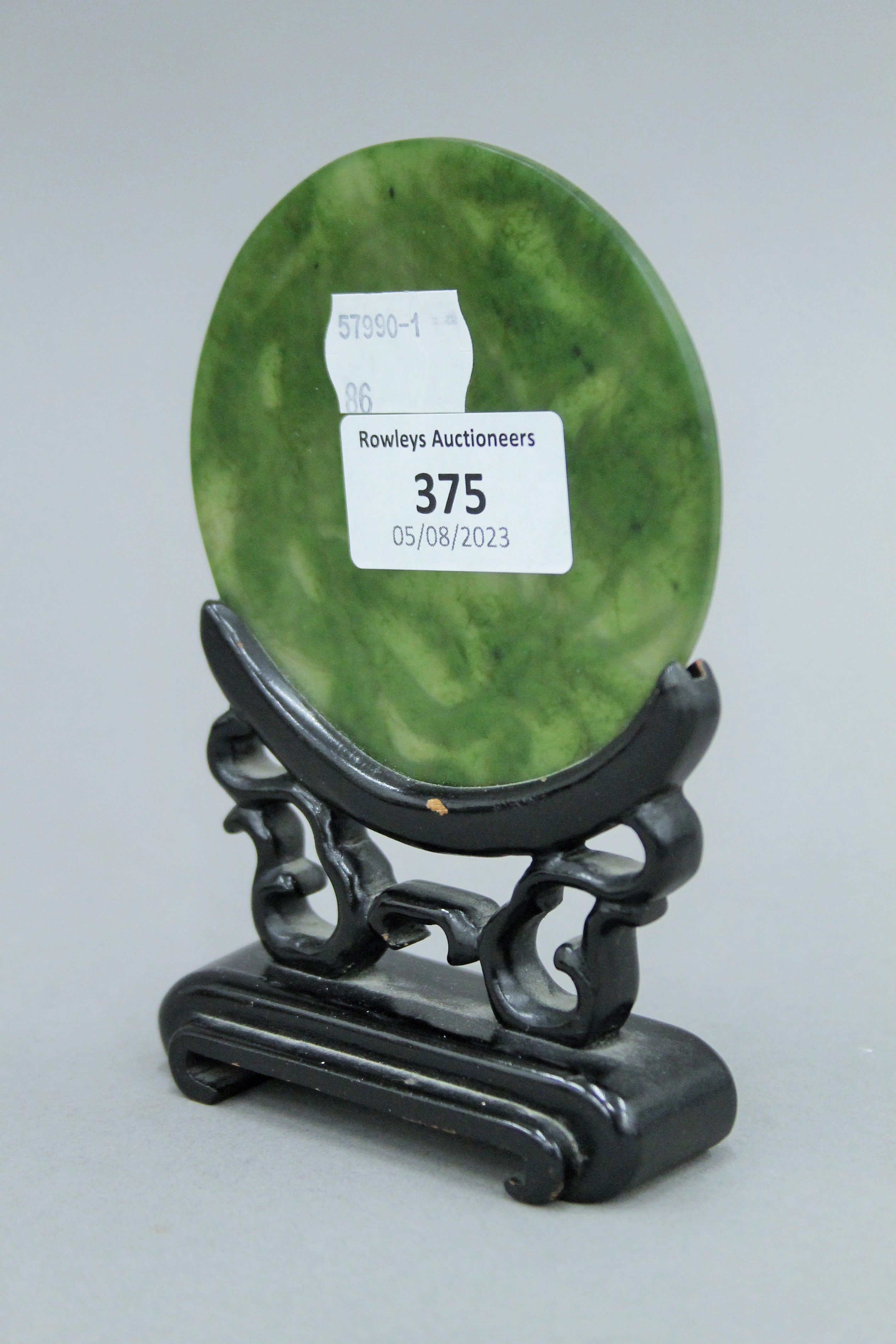 A small Chinese carved spinach jade disc on carved wooden stand. 13.5 cm high. - Image 4 of 4