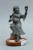 An 18th century Chinese bronze model of a dancing figure mounted on a wooden plinth base.
