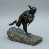 A patinated bronze model a faun and a goose mounted on a carved stone base. 26 cm high.