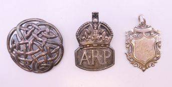 Two silver brooches and a silver fob.