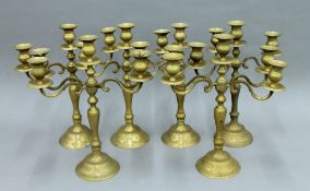 Seven brass candelabra. Each approximately 39.5 cm high.