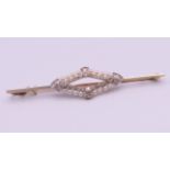 An unmarked gold diamond and seed pearl bar brooch. 6.5 cm long. 4.7 grammes total weight.