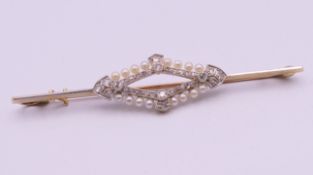 An unmarked gold diamond and seed pearl bar brooch. 6.5 cm long. 4.7 grammes total weight.