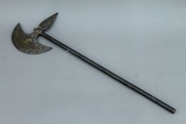 An antique engraved steel axe with brass inlays. 75 cm high.