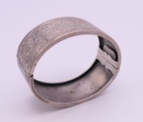 An engraved silver bangle form bracelet. 6.5 cm wide. 28.6 grammes.