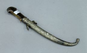 An antique horn (possibly rhino) handled jambiya in unmarked white metal scabbard. 38.5 cm long.
