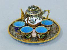 A miniature cloisonne tea set, in box. The teapot 4 cm high.