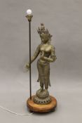 A floor lamp set with a brass model of Guanyin. 107 cm high overall.
