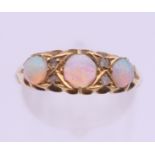 An 18 ct gold three stone opal ring. Ring size N/O. 2.6 grammes total weight.