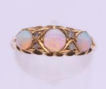 An 18 ct gold three stone opal ring. Ring size N/O. 2.6 grammes total weight.