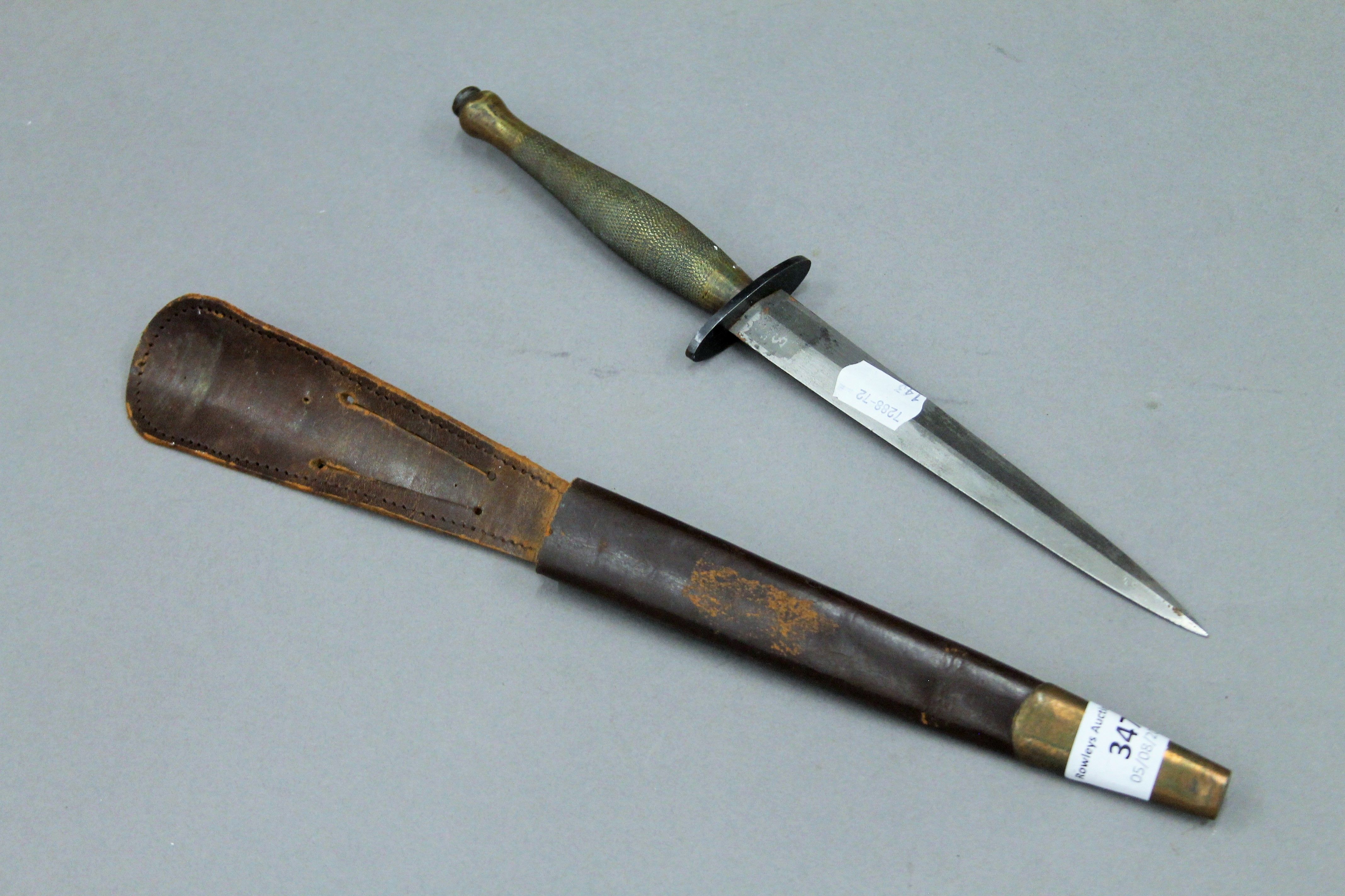 A Fairbairn-Sykes fighting knife in leather scabbard. 31.5 cm long. - Image 2 of 7