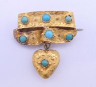A turquoise set ribbon brooch with heart drop. 3 cm high.