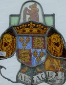 An antique stained glass panel centred with an heraldic crest.