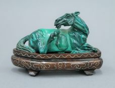 A Chinese carved malachite reclining horse on stand. The stand 11 cm long.
