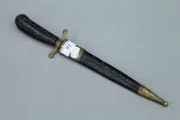 A 19th century dagger in brass mounted leather sheath. 37.5 cm long.