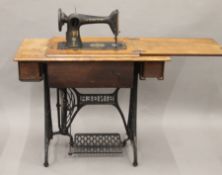 A Singer sewing machine on original treadle base. 91.5 cm long.